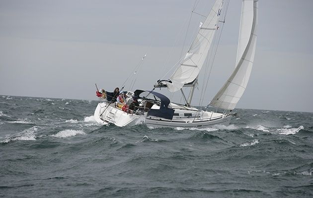 Segelboot mit gesetzten Segeln bei starkem Wind und unruhiger See